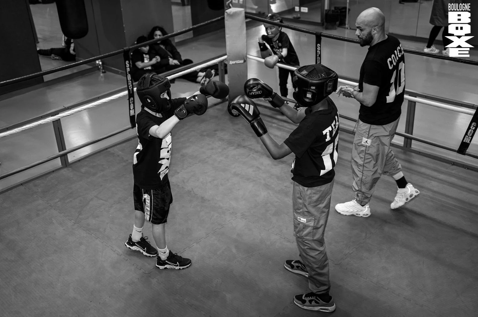 Oualid Belaoura coache deux jeunes boxeurs en opposition sur le ring